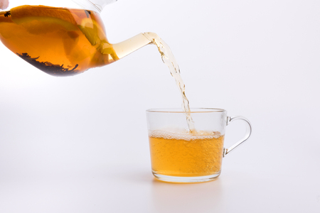 Green tea pouring into glass cup Isolated on white backgroundの写真素材