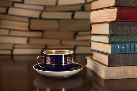 cup of tea and many books on a wooden tableの写真素材