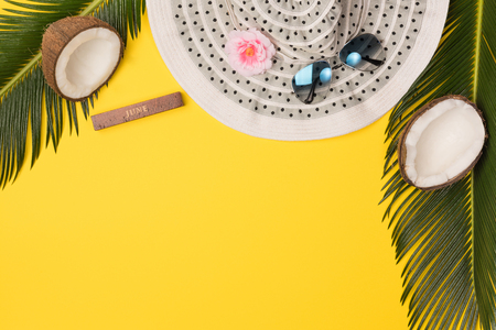 hat, coconuts and palm leaves isolated on yellow background, top viewの写真素材