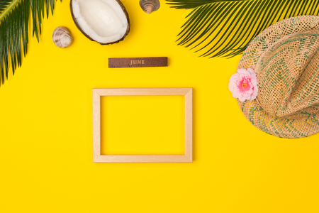 Stylish summer composition with photo frame, green leaves, hat and coconut on a blue pastel background. Artwork mockup with copy spaceの写真素材