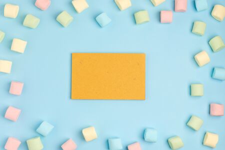 Blue paper background with marshmallow and notepad. Place for your text. Cozy sweet backgroundの写真素材