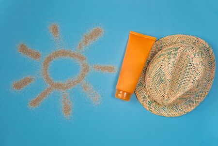 Sunscreens isolated on blue background. Sun drawn by the sand on blue background. Top view.の写真素材