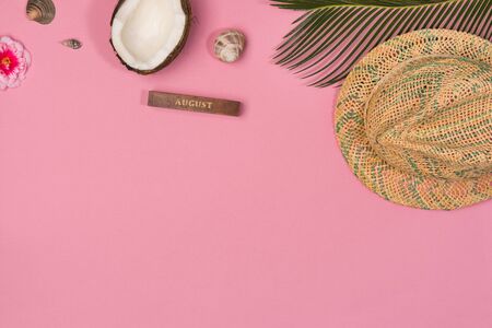 Summer vacation concept. stylish hat and green palm leaves on pink background, flat lay. space for text.の写真素材