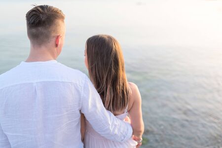 Summer couple embracing at sunset on beach. Romantic young couple enjoying sun, sunshine, romance...