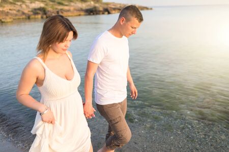 Couple holding hands walking romantic on beach on vacation travel holidays. Closeup of body and...