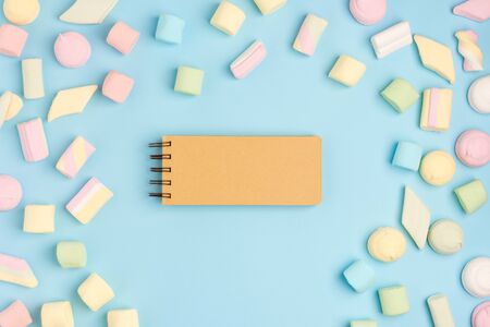 Blue paper background with sugary jellies and blank notepad. Place for your text. Cozy sweet backgroundの写真素材