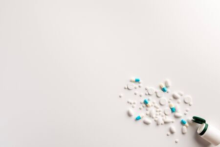 Bottle with scattered pills on white background. Flat lay.の写真素材