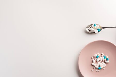 Plate and spoon with pills. Flat lay.の写真素材