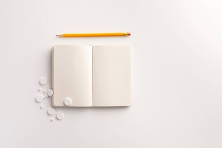 Pills, notepad and pencil on white background. Medical concept. Flat lay.の写真素材