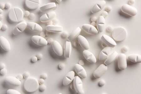 White pills on white background. Flat lay.