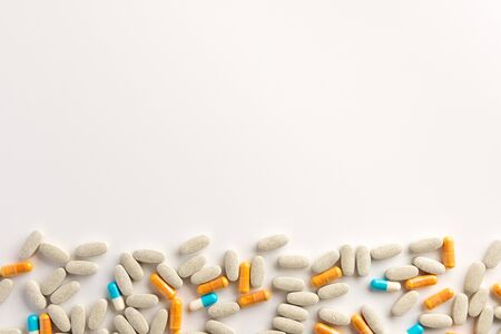 Different pills scattered on white background. Flat lay.