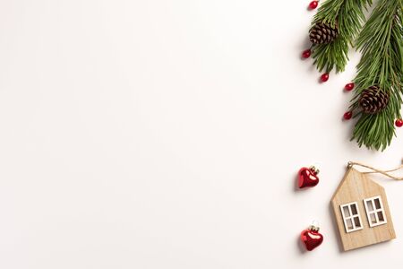 Christmas composition. Spruce branches with wooden small house, on a white background. Christmas, winter concept. Flat lay, top view, copy space.の写真素材