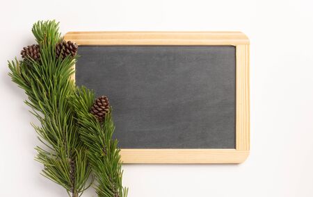 Christmas composition. Spruce branches and blank blackboard, on a white background. Flat lay, top...