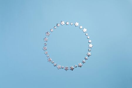 Winter Christmas card composition with silver stars, Xmas decorations on blue background. Winter decorations borderの写真素材