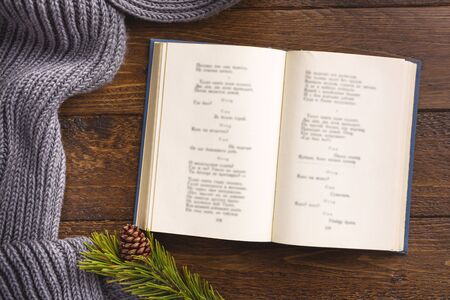 Open book and winter decor, on wooden background. Flat lay, top view, copy space.の写真素材