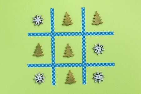 Tic tac toe game with christmas toys, isolated on green background. Christmas, winter concept. Flat lay, top view.の写真素材