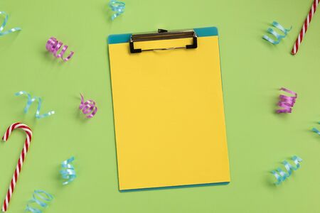 Celebration planning concept. Clipboard and serpentine, on green background. Flat lay, top view, copy space.の写真素材