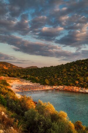 Sunset at Atspas Beach. Famous beach of Thassos island. Sun umbrellas and sun loungers.の写真素材
