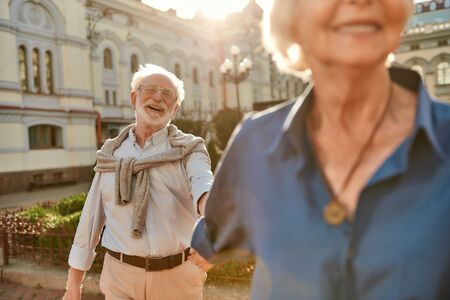 Time doesnt matter love is forever. Beautiful and happy elderly couple holding hands and smiling while spending time together outdoorsの写真素材