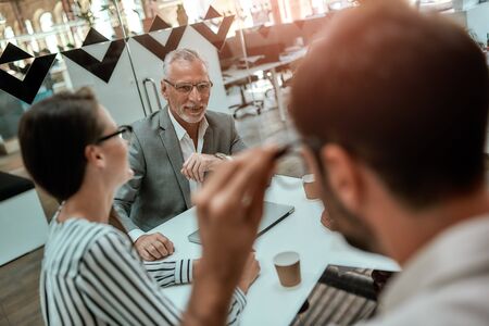 Office workers. Group of business people discussing something while sitting at the office table together. Brainstorming. Teamworkの写真素材