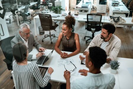 Top view of business people discussing something while working together in the modern officeの写真素材