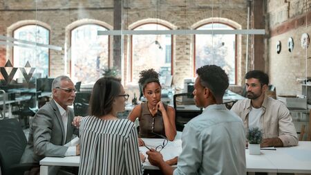 Important meeting. Group of business people discussing something and working together while sitting at the office tableの写真素材