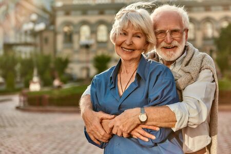 Love has no age limit. Happy senior couple in casual clothing embracing each other and smiling while standing outdoors. Love concept. Familyの写真素材