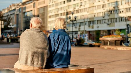 Resting. Back view of senior couple in casual clothes sitting on the bench together. Senior man and womanの写真素材