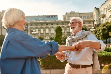You are my soul! Beautiful senior couple smiling and dancing outdoors on a sunny day. Having fun. Love concept. Happy momentsの写真素材
