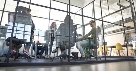 Brainstorming. Group of multiracial business people working together, discussing project while...