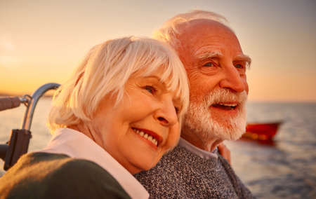 In love. Close up portrait of a beautiful and happy senior couple hugging, relaxing and smiling...