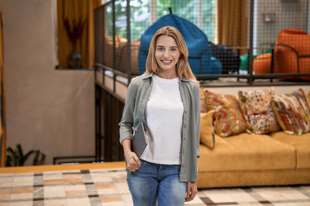 Portrait of a young beautiful caucasian businesswoman or female office worker looking at camera and...