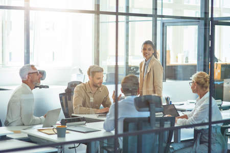 Project team at work. Group of multiracial business people sitting in board room in the modern office and discussing something while having a meetingの写真素材