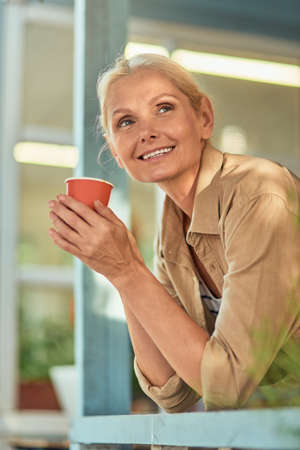 Business woman peeking out of windowの写真素材
