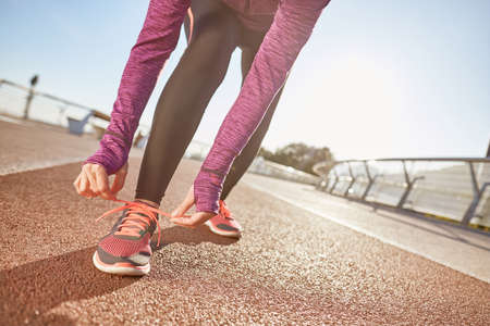 Being prepared. Cropped shot of active mature woman wearing sportswear tying her shoe laces while...