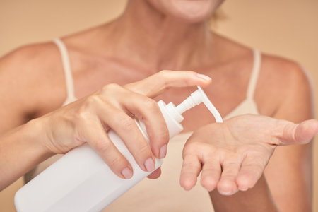 Woman is applying cream on her palmの写真素材