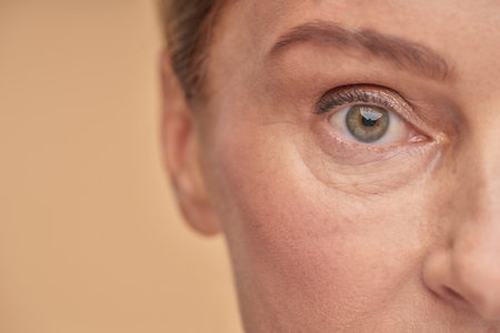 Mature woman with wrinkled eyes in studioの写真素材