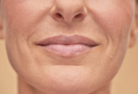 Beautiful female face studio shot on a beige backgroundの写真素材