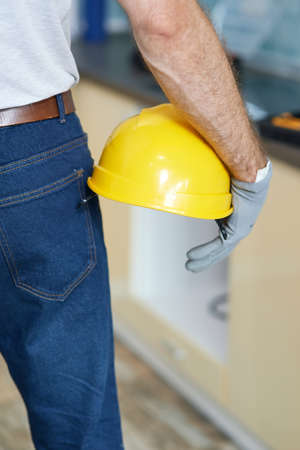 Close up shot of professional repairman holding a helmet while standing indoorsの写真素材