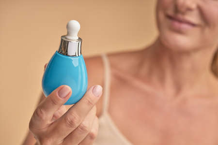 Happy lady holding professional face care productの写真素材