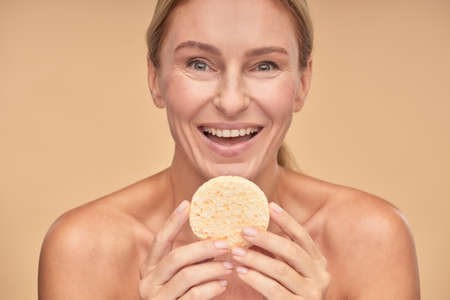 Adult lady having fun while holding sponge in handsの写真素材