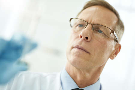 Handsome male doctor in glasses on white blurred backgroundの写真素材