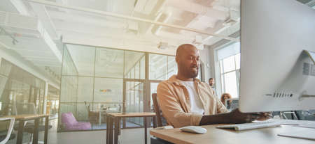 Ambitious African American gentleman working at modern officeの写真素材