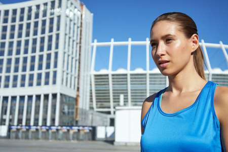 Portrait of young caucasian woman in front of stadiumの写真素材