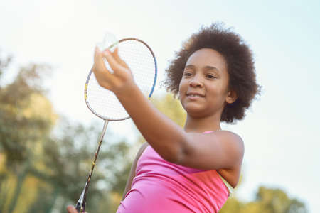 Adorable little girl playing badminton on the streetの写真素材