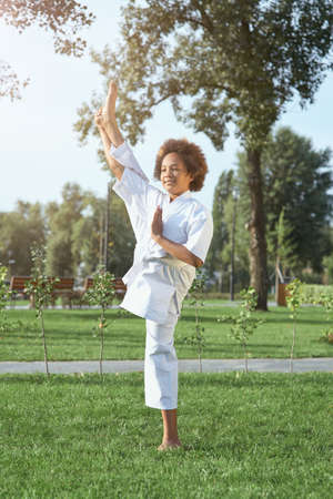 Cute female child karateka doing exercise outdoorsの写真素材