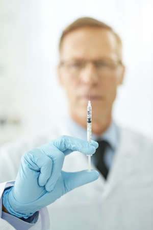 Male doctor hand holding syringe with vaccine