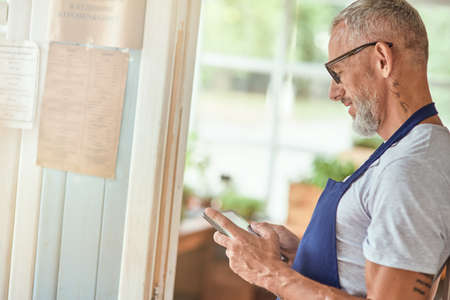 Middle aged caucasian man looking in tablet screenの写真素材