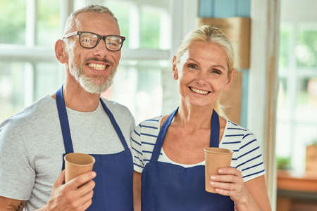 Middle aged caucasian couple holding paper cupsの写真素材