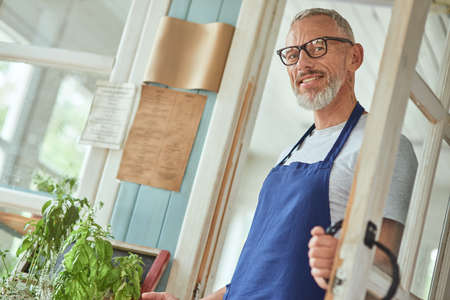 Middle aged caucasian man holding handle on doorの写真素材